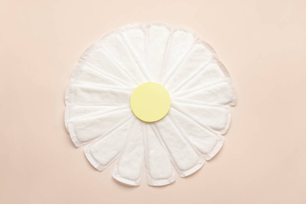 Chamomile flower made of menstrual pads on color background - Photo, Image