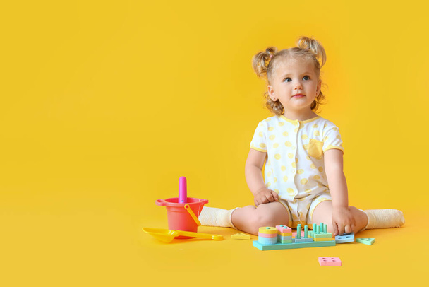 Linda niña con juguetes en el fondo de color - Foto, imagen