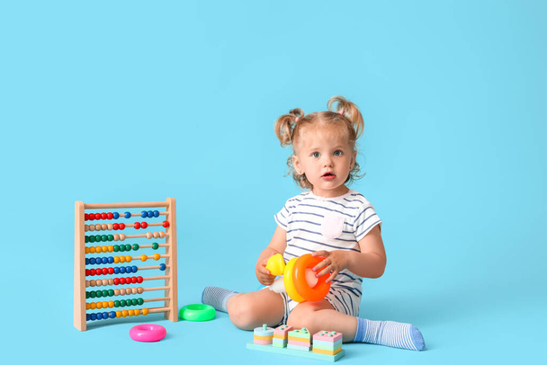 мила дівчинка з іграшками на кольоровому фоні
 - Фото, зображення
