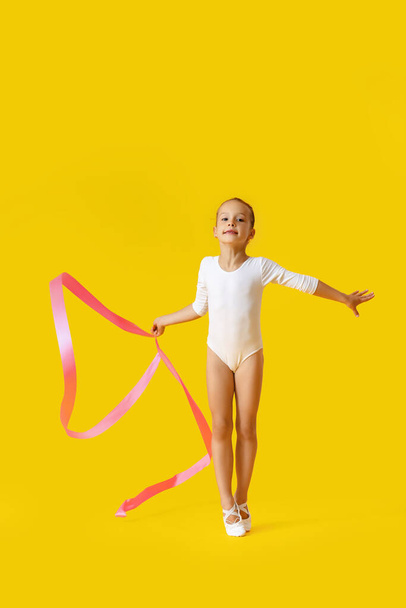 Niña haciendo gimnasia con cinta sobre fondo de color - Foto, Imagen
