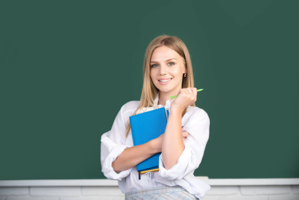 Portrait of female university student study lesson at school or university. Creative young smiling female student with pen and book. - Foto, imagen