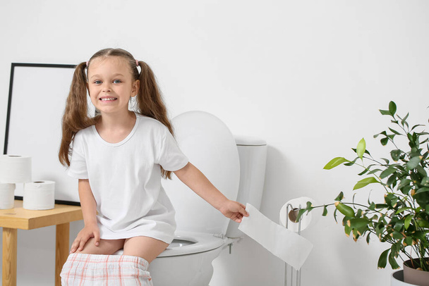 Bambina seduta sulla tazza del water in bagno - Foto, immagini