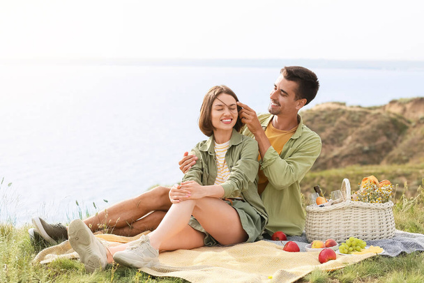 Happy young couple having romantic picnic in mountains - Photo, image