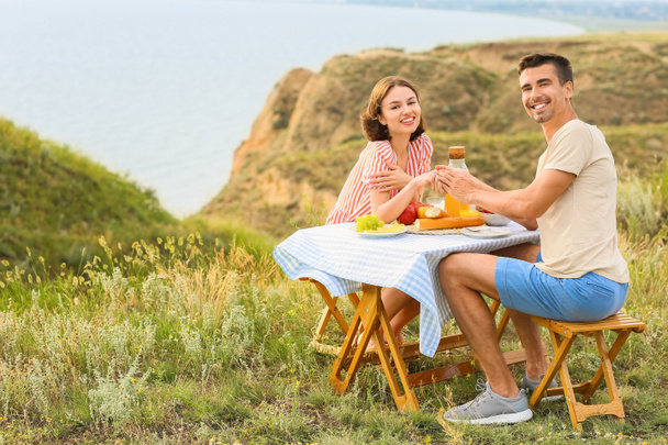 Щаслива молода пара має романтичний пікнік в горах
 - Фото, зображення
