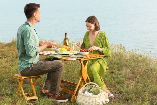 Felice giovane coppia avendo romantico picnic vicino al mare - Foto, immagini