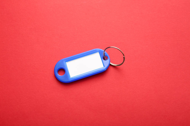 Πλαστική ετικέτα κλειδιού σε κόκκινο φόντο - Φωτογραφία, εικόνα