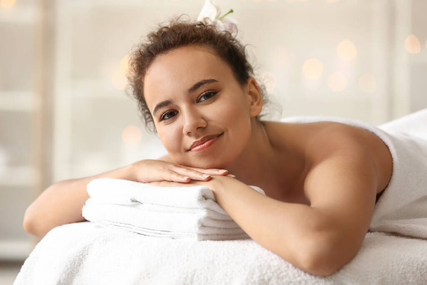 Fiatal afro-amerikai nő fekszik a kanapén spa szalonban - Fotó, kép