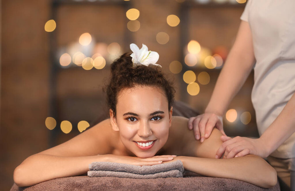 Piękna Afroamerykanka otrzymuje masaż od terapeuty w salonie spa - Zdjęcie, obraz
