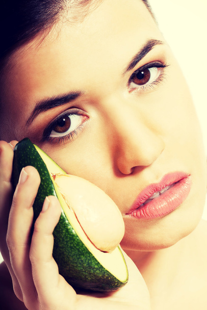 Beautiful woman holding avocado. - Zdjęcie, obraz