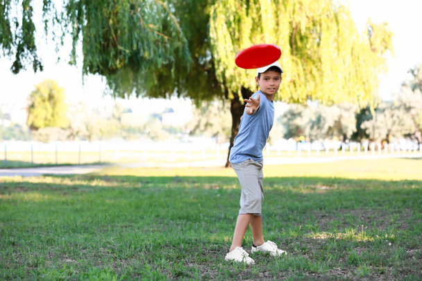 Cute little boy playing frisbee outdoors - Photo, Image