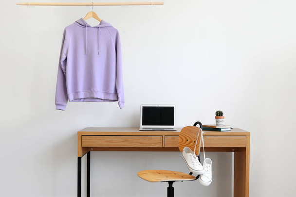 Workplace near wall with hanging hoodie - Photo, Image