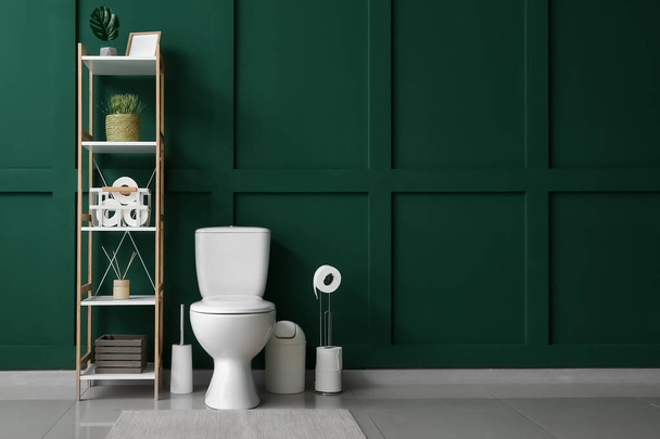 トイレボウル、棚ユニット、緑の壁付きトイレのインテリア - 写真・画像