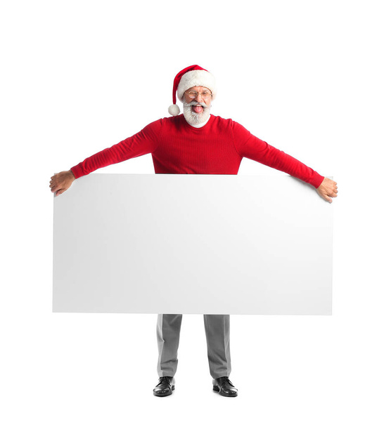 Funny mature man in Santa Claus hat and with blank poster on white background - Photo, Image