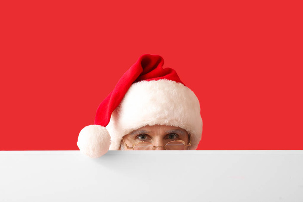 Santa Claus with blank poster on color background - Foto, Bild