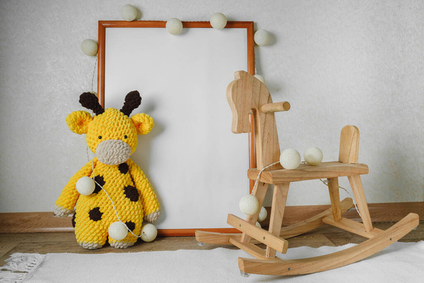 Maquette de la photo dans la chambre des enfants. Cheval en bois et jouets tricotés. L'intérieur de la pépinière aux couleurs beiges. - Photo, image