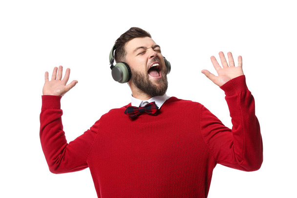 Young man with headphones singing on white background - Φωτογραφία, εικόνα