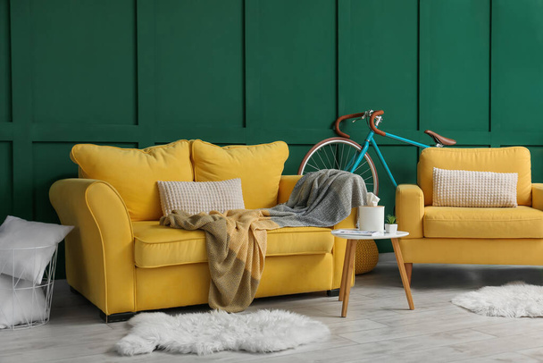 Interiér obývacího pokoje se žlutou pohovkou, křeslem a jízdním kolem - Fotografie, Obrázek
