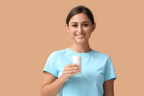 Jovem com copo de leite orgânico no fundo de cor - Foto, Imagem