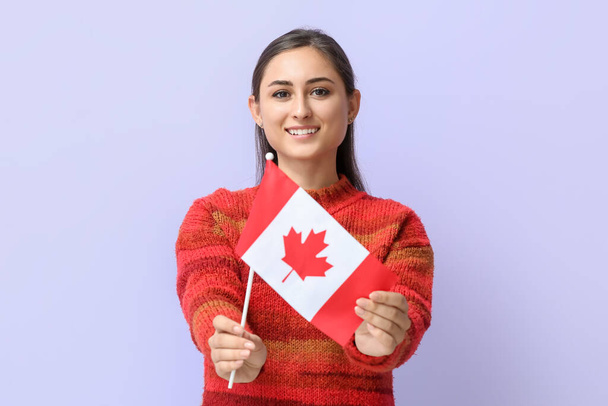 Молода жінка з національним прапором Канади на кольоровому тлі - Фото, зображення