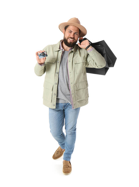 Handsome man with Black Friday shopping bags and gift card on white background - Foto, Imagem