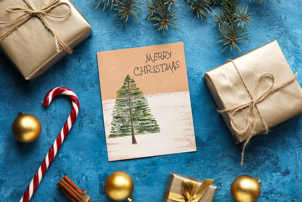Cartão com texto MERRY CHRISTMAS, presentes e decoração em fundo azul - Foto, Imagem