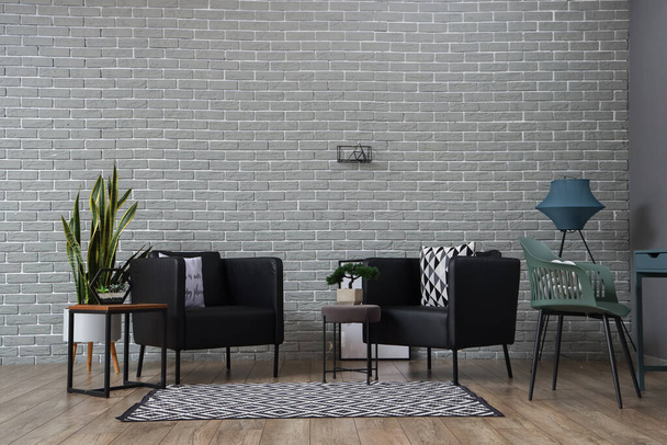 Belső tér elegáns nappali modern fotelekkel és téglafal - Fotó, kép
