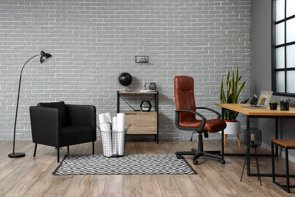 Interior of stylish room with modern workplace and brick wall - Photo, Image