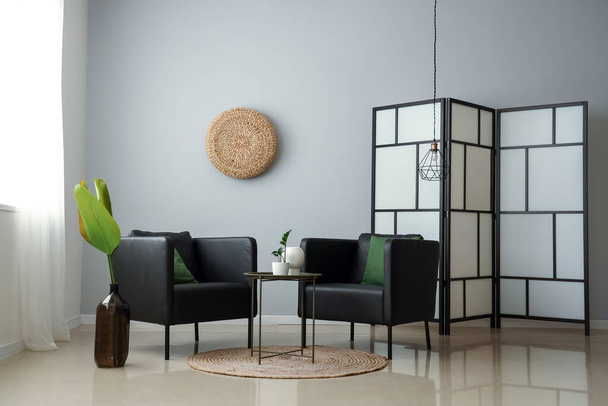 Interior de la elegante sala de estar con sillones modernos y pantalla plegable - Foto, Imagen