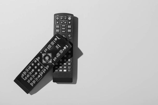Black TV remote controllers on grey background - Photo, Image
