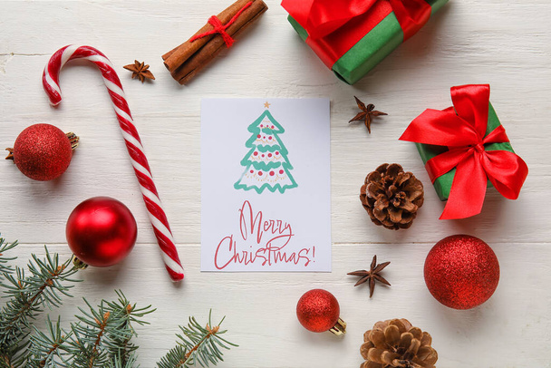 Pozdrav s textem MERRY CHRISTMAS, dekorace a dárkové krabice na bílém dřevěném pozadí - Fotografie, Obrázek