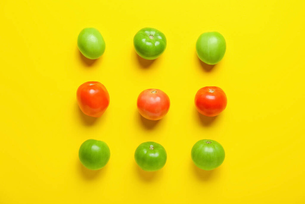 Green and ripe tomatoes on yellow background - Foto, imagen