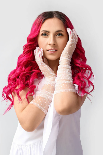 Beautiful woman with unusual bright hair color on light background - Zdjęcie, obraz