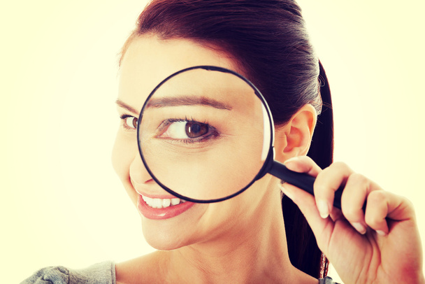 Young beautiful woman with magnifying glass. - Foto, imagen