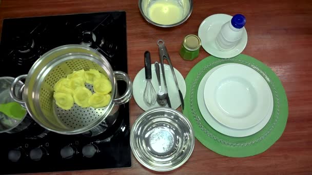 Kook een heerlijke maaltijd. Italiaanse keuken. Pan op het fornuis met ravioli noedels. - Video