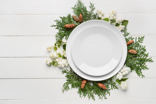Masa düzeniyle kompozisyon, köknar dalları ve beyaz ahşap arka planda kar çilekleri - Fotoğraf, Görsel
