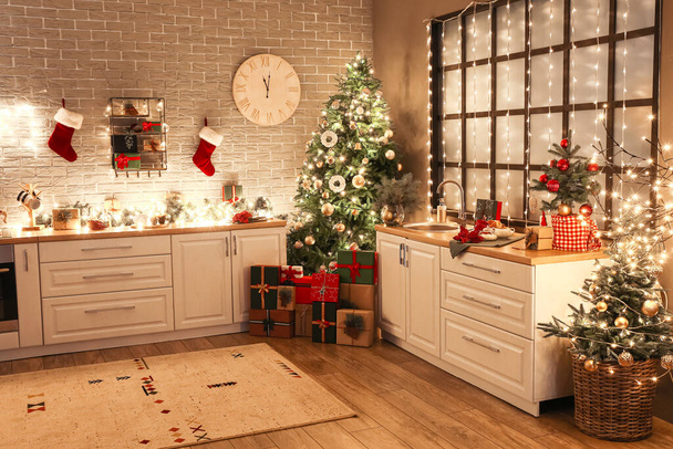 Modern mutfağın içinde Noel ağacı, hediye kutuları ve şık bir dekor var. - Fotoğraf, Görsel