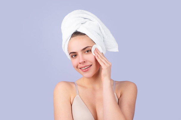 Portrait of young beautiful woman after bath. Beauty face of a cheerful attractive girl with towel on head, isolated. Moisturized healthy skin, morning spa, beauty routine, facial skincare treatment. - Фото, изображение