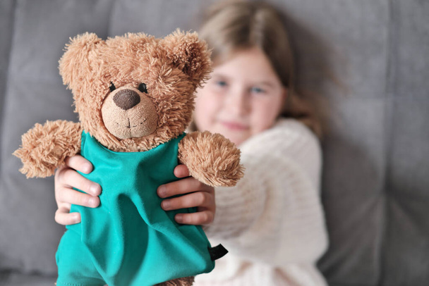 little girl holding her toy best friend teddy bear and showing it to a viewer. kids favorite toys, playing with children, happy and cheerful girl - Fotografie, Obrázek