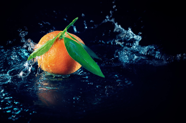 Naranja sobre fondo negro con agua
 - Foto, Imagen
