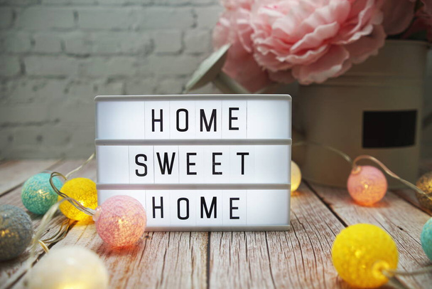 Home Sweet Home text on lightbox on wooden background - Valokuva, kuva