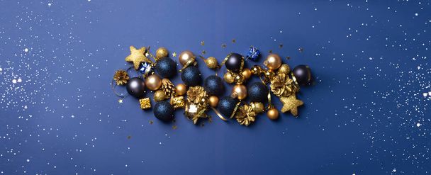 Mooie gouden zilveren decoraties Kerst speelgoed op een donkerblauwe achtergrond - Foto, afbeelding