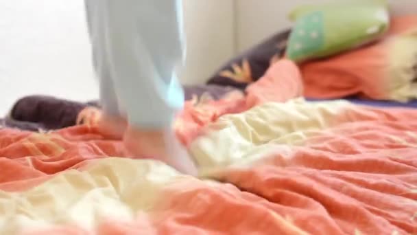 Niño (niño) salta en la cama - detalle de las piernas
 - Metraje, vídeo