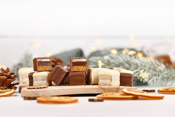 Christmas sweets called 'Dominosteine'. German candy consisting of gingerbread, jelly and marzipan layers covered with chocolate icing  - Foto, afbeelding