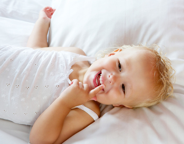 Linda niña riendo en la cama
 - Foto, imagen
