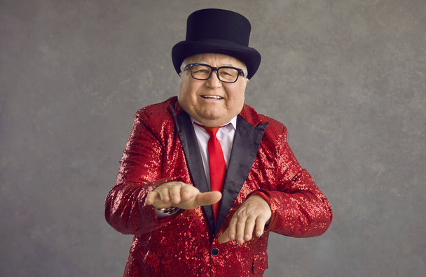 Funny fat senior man in a red sequin jacket having fun at a crazy retro disco party - Foto, Imagen