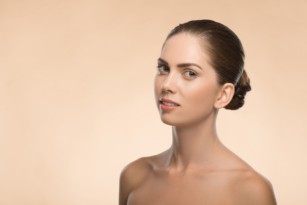 Young woman with beautiful healthy face - isolated on beige back - Foto, imagen
