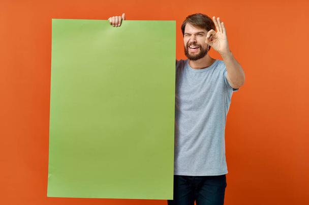 Sakallı adam izole edilmiş arka planda yeşil bir pankart tutuyor. Yüksek kalite fotoğraf - Fotoğraf, Görsel
