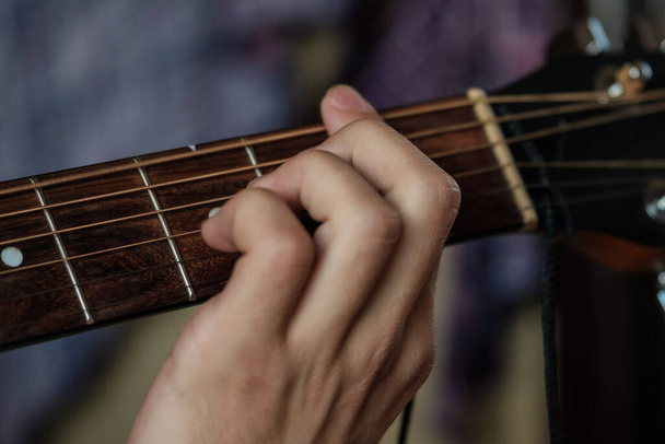 Hand playing masterly on a guitar. - Zdjęcie, obraz
