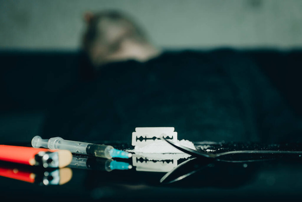 Addict young caucasian man dead after inject drug overdose with syringe injection heroin to hand.Social disaster and epidemic of narcotic addiction concept.Toned. - Zdjęcie, obraz