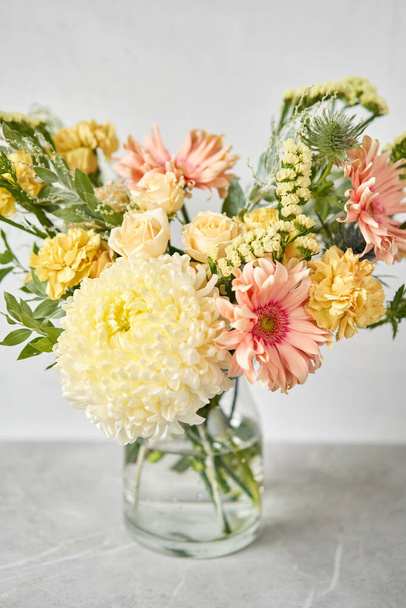 Ολοκληρωμένη σύνθεση λουλουδιών σε ένα βάζο για το σπίτι. Λουλούδια, έτοιμα για το εσωτερικό. Φρέσκα κομμένα λουλούδια για διακόσμηση σπιτιού. Ευρωπαϊκό ανθοπωλείο. Παράδοση φρεσκοκομμένων λουλουδιών. - Φωτογραφία, εικόνα